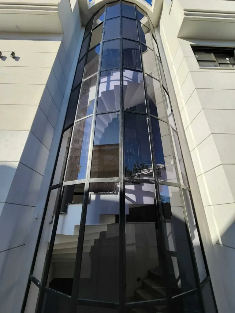 מעקה זכוכית מודרני עם מדרגות פנימיות, משקף עיצוב ייחודי ומתקדם.
זכוכית לפיר מעלית, חיפוי זכוכית למעלית, מעלית זכוכית